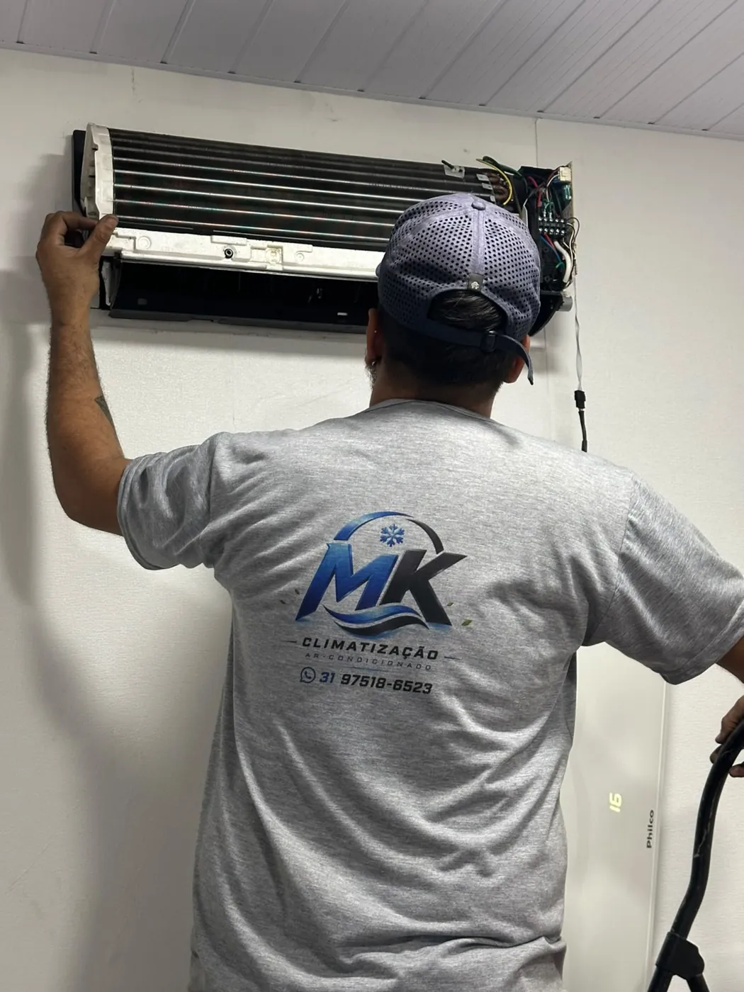 Técnico da MK Climatização higienizando evaporadora de ar-condicionado em Belo Horizonte