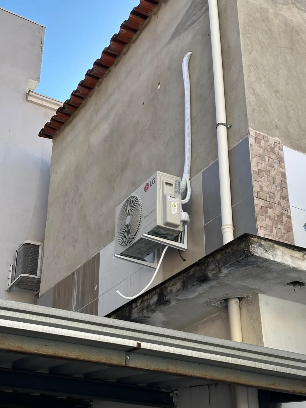Condensadora instalada em fachada recebendo manutenção preventiva na Grande BH